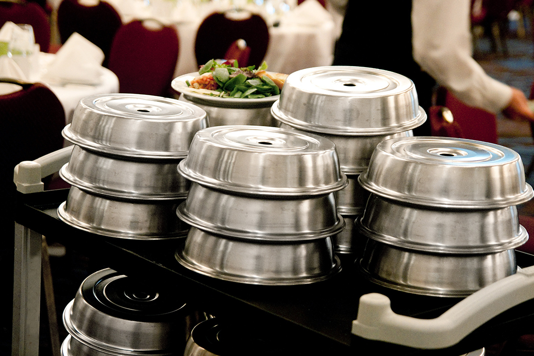 Catering cart with two tiers that are stacked high with individual meals