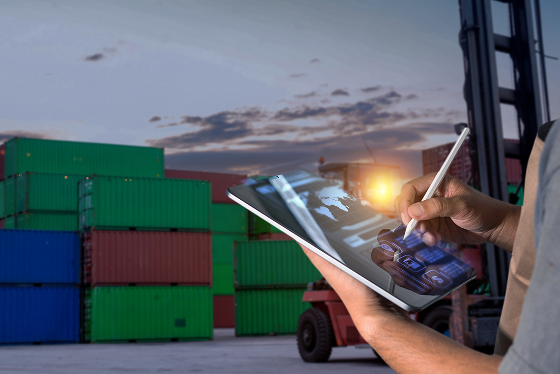 Worker in a yard uses tablet to record location of goods