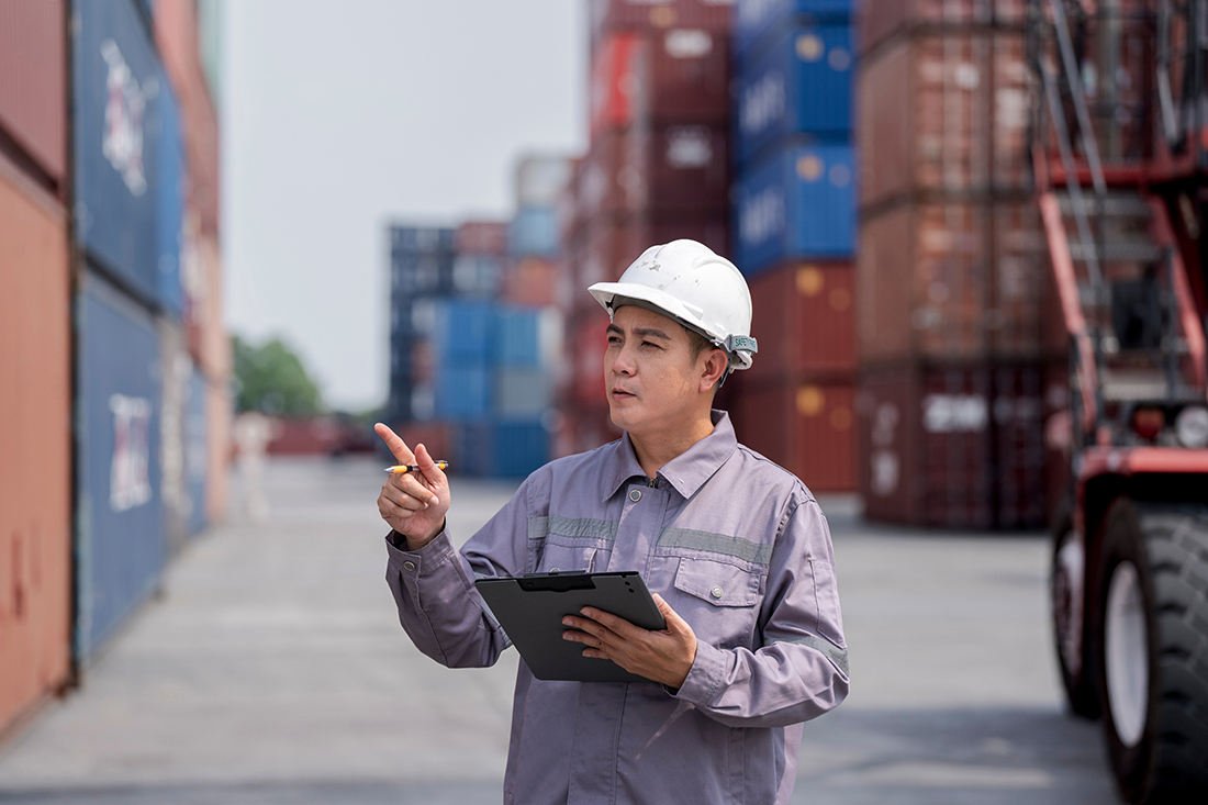 Employee in a logistics center yard looks frustrated while doing inventory.